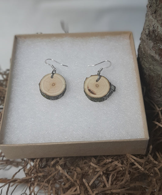 Wooden earrings on a textured surface with a neutral background